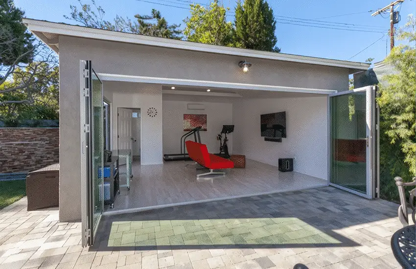 Garage converted to a flex studio with folding glass doors opening to a patio
