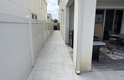 Tiled side-yard walkway with vinyl privacy fence