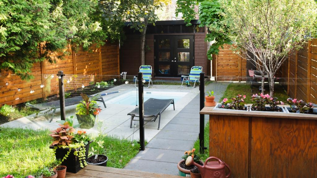 Backyard remodeling design featuring a modern outdoor living space with a pool, patio, seating area, privacy fence, and landscaped yard