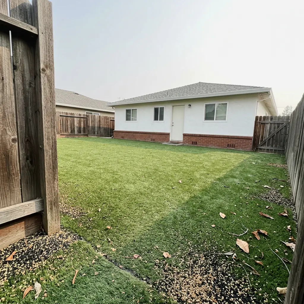 Full artificial turf lawn filling a backyard with bright even green and clean edges