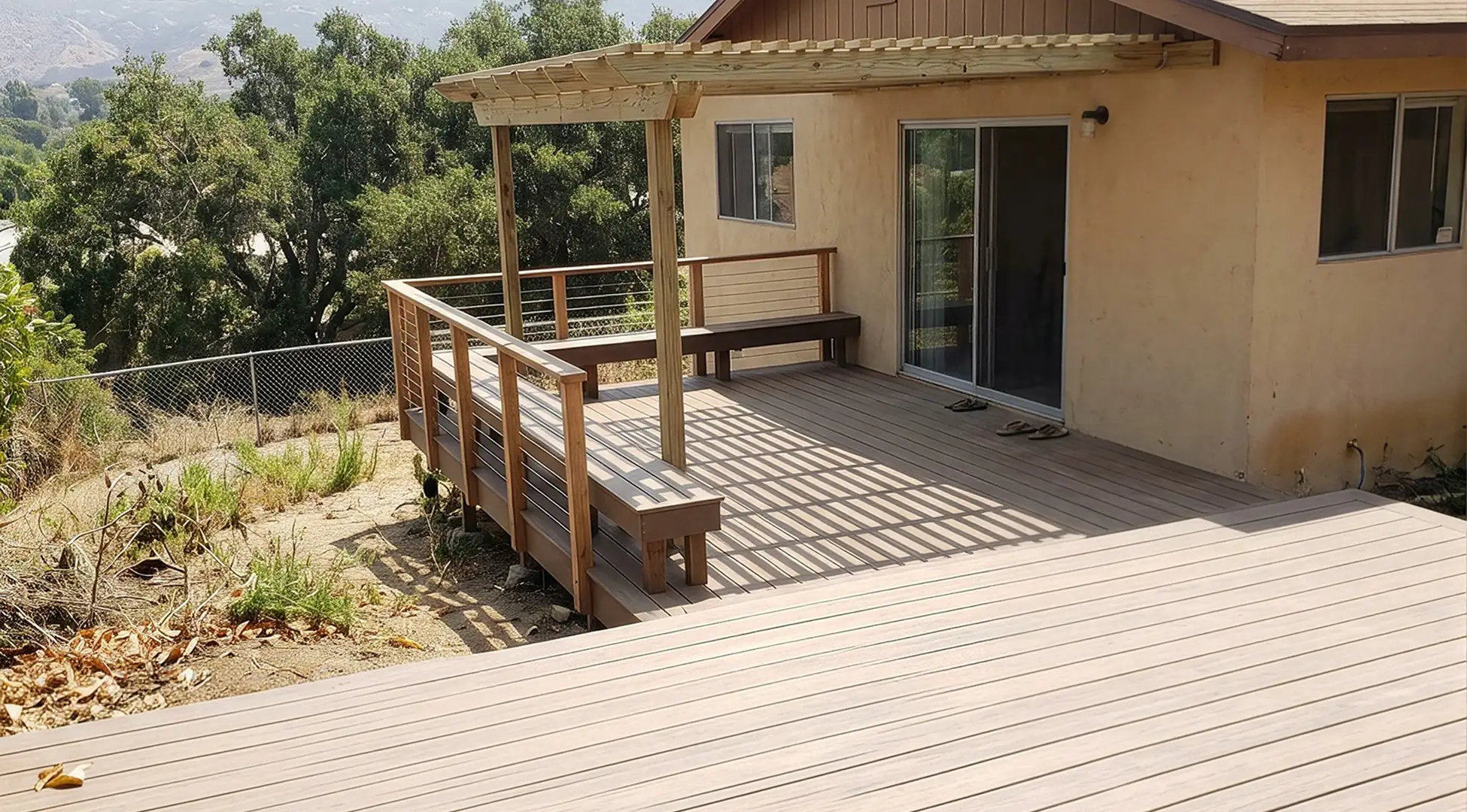 Composite deck with a pergola and built-in bench overlooking a sloped La Mesa yard with the East County ridge behind